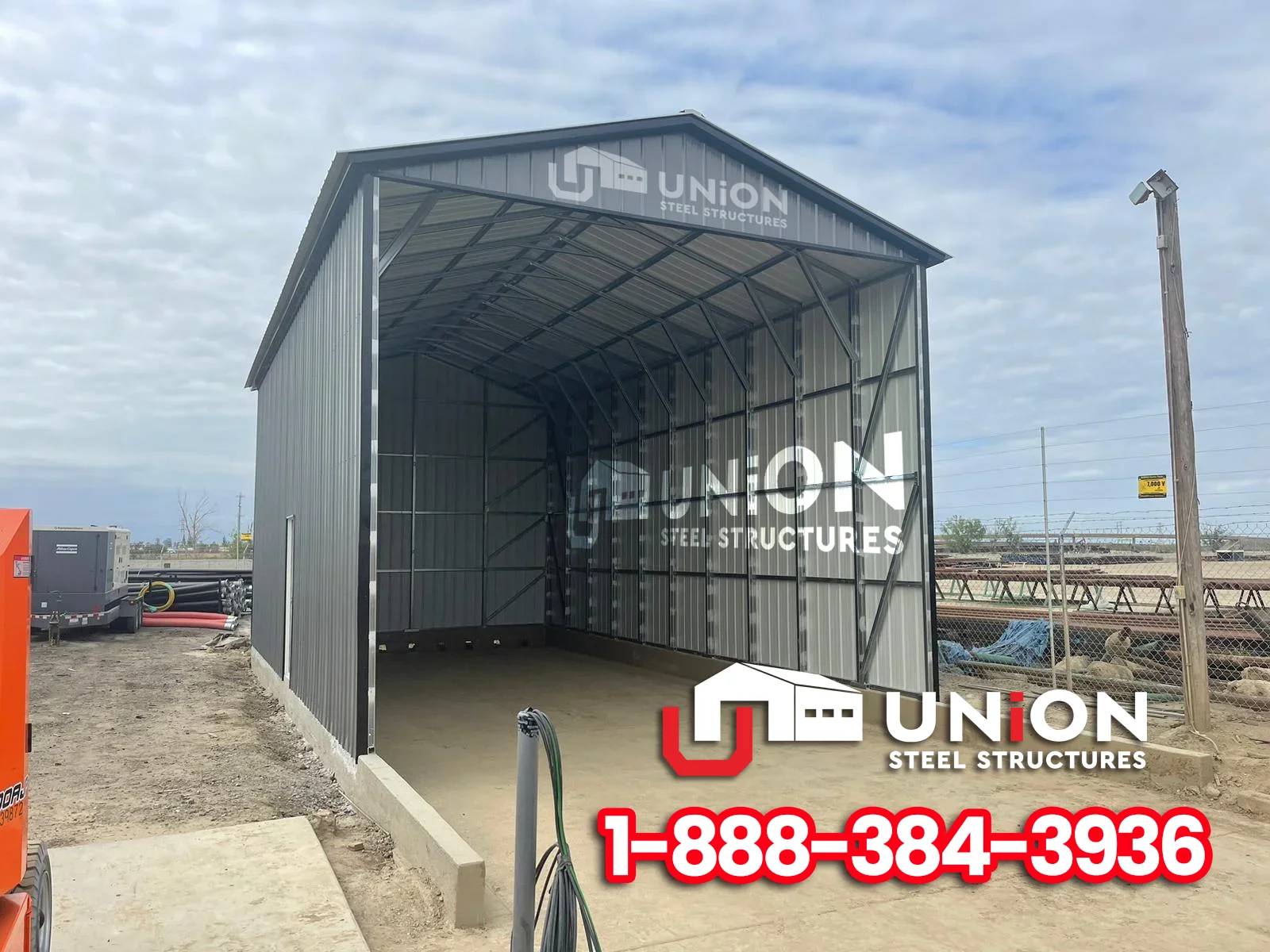 Tall gray metal RV shelter with an open front and enclosed sides.